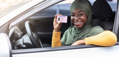 New driver holding up a driving licence from the car window